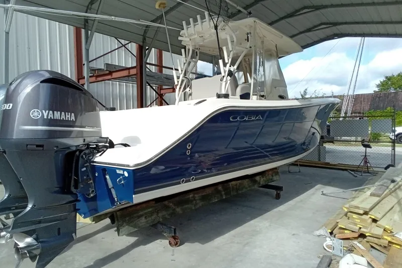 Slide: The Image of 2014 Cobia 296 Center Console boat with Yamaha engine in covered storage. - 20
