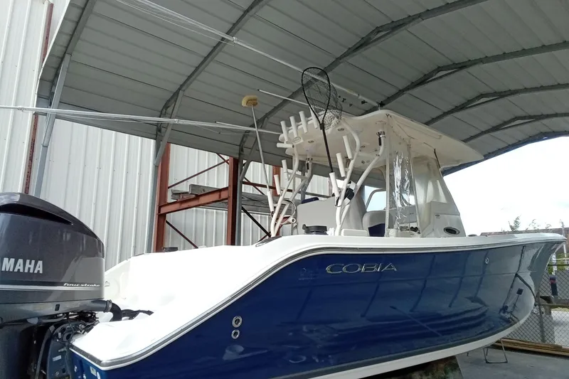 Slide: The Image of 2014 Cobia 296 Center Console boat with Yamaha engine, under a metal canopy. - 22