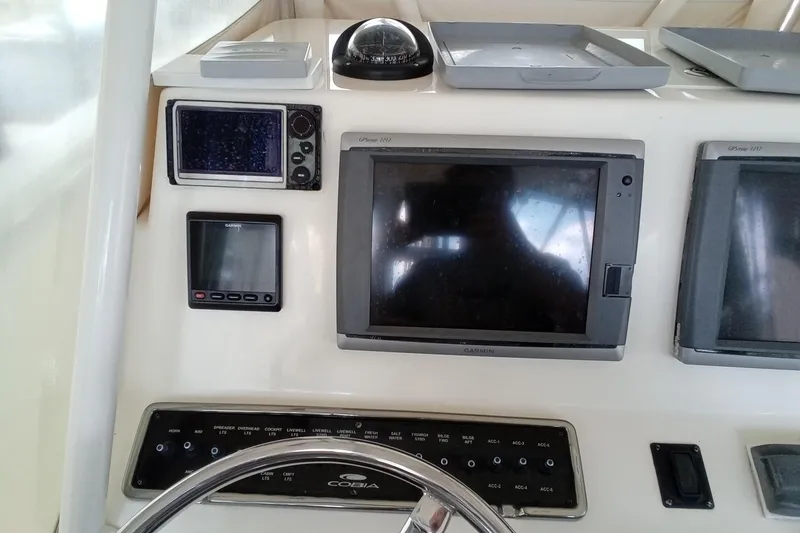 Slide: The Image of 2014 Cobia 296 Center Console dashboard with Garmin navigation displays and controls. - 29