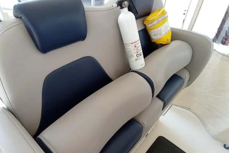 Slide: The Image of 2014 Cobia 296 Center Console boat seat with fire extinguisher and safety equipment. - 32