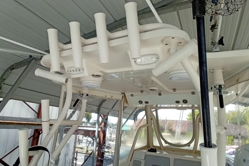 Slide: The Image of 2014 Cobia 296 Center Console boat with rod holders and navigation equipment. - 37