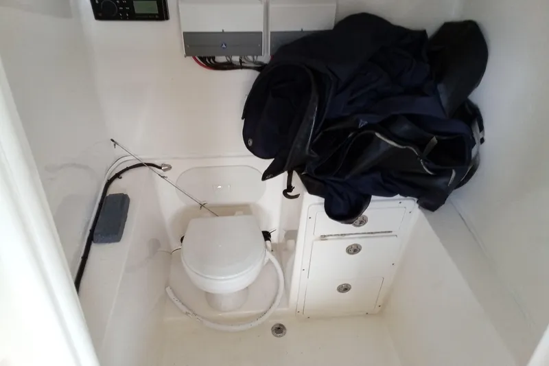 Slide: The Image of 2014 Cobia 296 Center Console boat interior with toilet and storage compartments. - 42