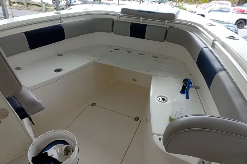 Slide: The Image of 2014 Cobia 296 Center Console boat interior with cushioned seating and storage compartments. - 47