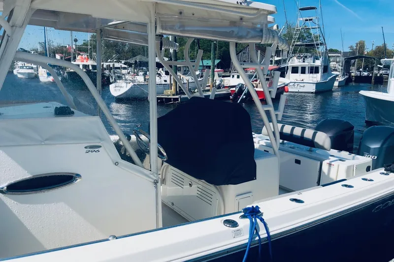 Slide: The Image of 2014 Cobia 296 Center Console boat docked at a marina with other vessels. - 5