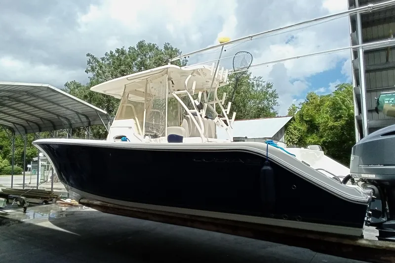 Slide: The Image of 2014 Cobia 296 Center Console boat on trailer under cloudy sky. - 54