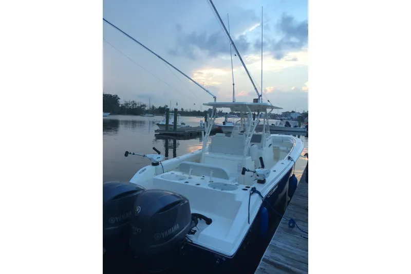 Slide: The Image of 2014 Cobia 296 Center Console boat docked at sunset with Yamaha engines. - 6