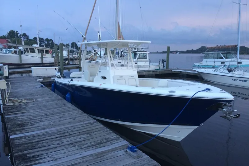 Slide: The Image of 2014 Cobia 296 Center Console boat docked at marina during twilight. - 7