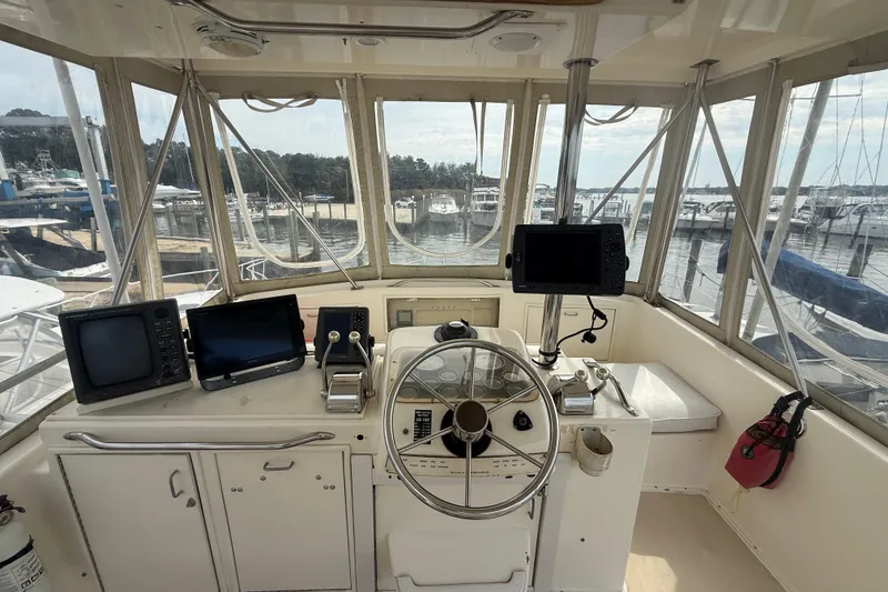 Slide: The Image of 1986 Ocean Yachts 38 Super Sport helm with navigation equipment and marina view. - 14