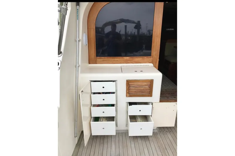 Slide: The Image of 1986 Ocean Yachts 38 Super Sport interior with open storage drawers and wooden accents. - 19