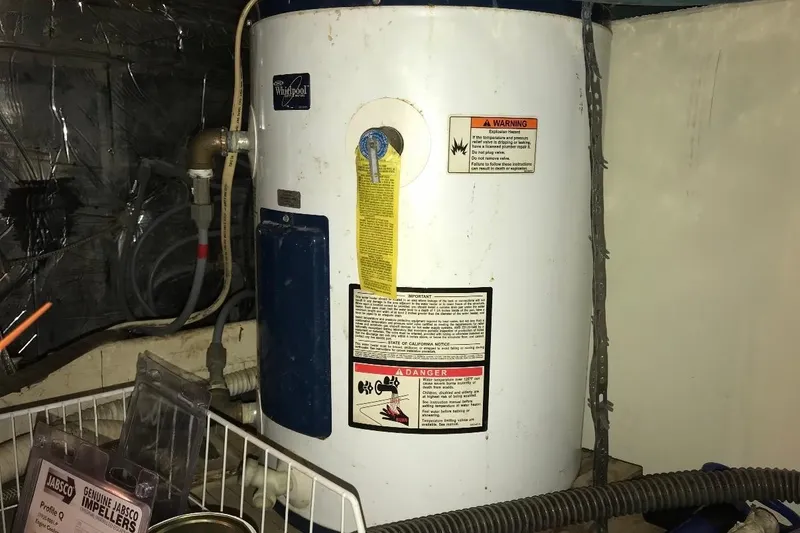 Slide: The Image of Water heater in 1986 Ocean Yachts 38 Super Sport engine room, surrounded by pipes and equipment. - 21