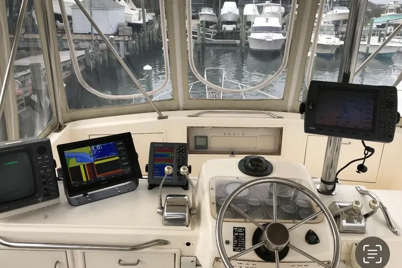 Slide: The Image of 1986 Ocean Yachts 38 Super Sport helm with navigation equipment and marina view. - 24