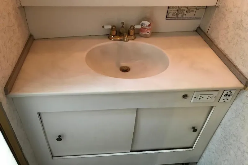 Slide: The Image of 1986 Ocean Yachts 38 Super Sport bathroom sink with faucet and storage cabinet. - 26