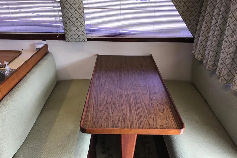 Slide: The Image of 1986 Ocean Yachts 38 Super Sport interior with wooden table and cushioned seating. - 27