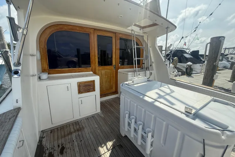 Slide: The Image of 1986 Ocean Yachts 38 Super Sport boat deck with wooden doors and fishing equipment. - 4