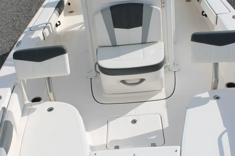 Slide: The Image of 2023 Robalo 226 Cayman boat interior with white seating and storage compartments. - 10