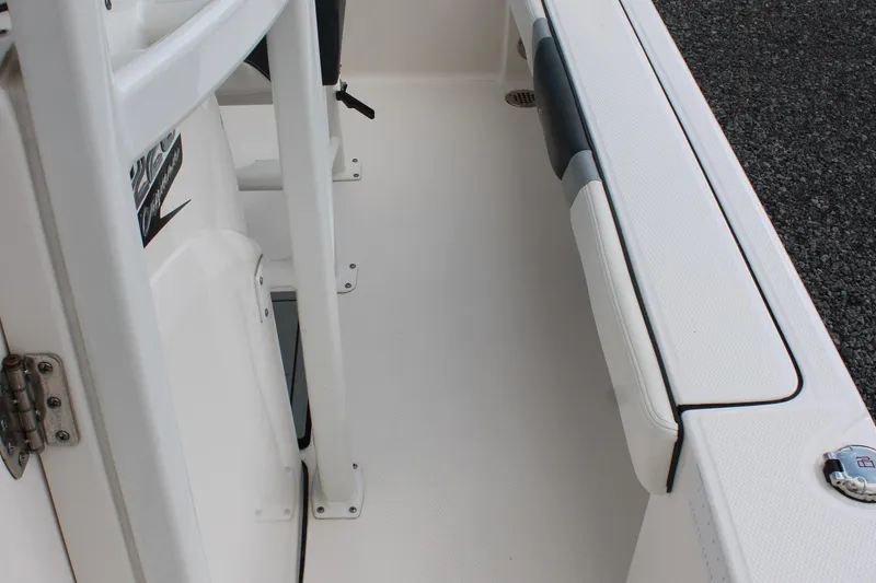 Slide: The Image of 2023 Robalo 226 Cayman boat interior, featuring white seating and storage compartments. - 14