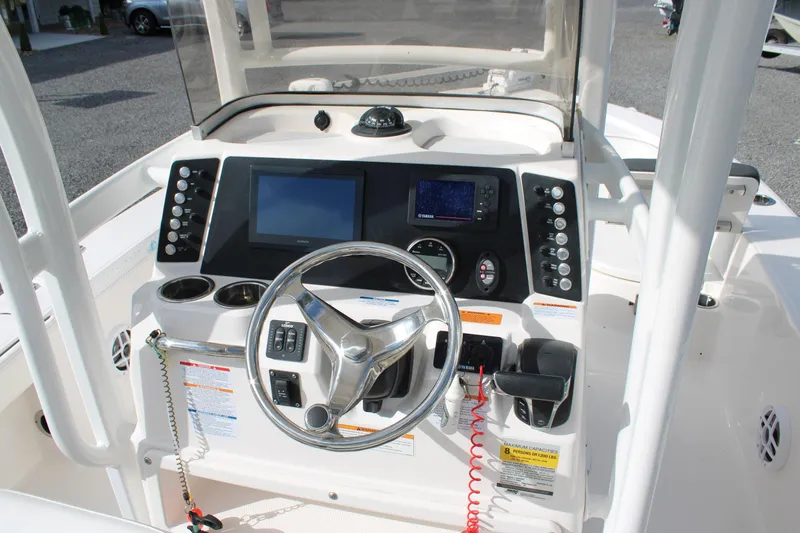 Slide: The Image of 2023 Robalo 226 Cayman boat dashboard with steering wheel and electronic controls. - 18