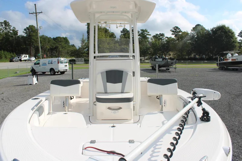 Slide: The Image of 2023 Robalo 226 Cayman boat with seating and trolling motor, parked outdoors. - 8