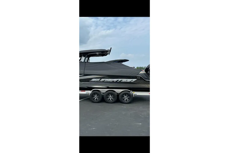 Slide: The Image of 2023 Sunsation 32 CCX boat on trailer, covered, with triple-axle wheels. - 3