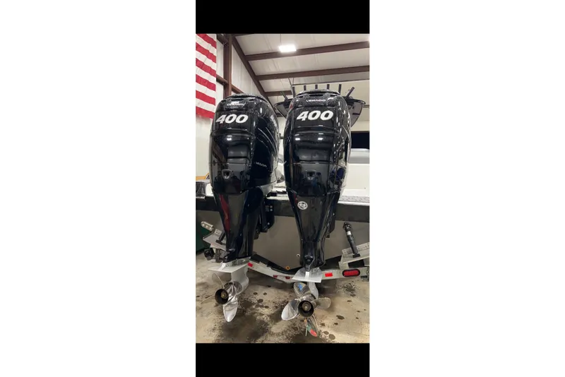 Slide: The Image of 2023 Sunsation 32 CCX with twin 400 horsepower outboard engines in a garage setting. - 5