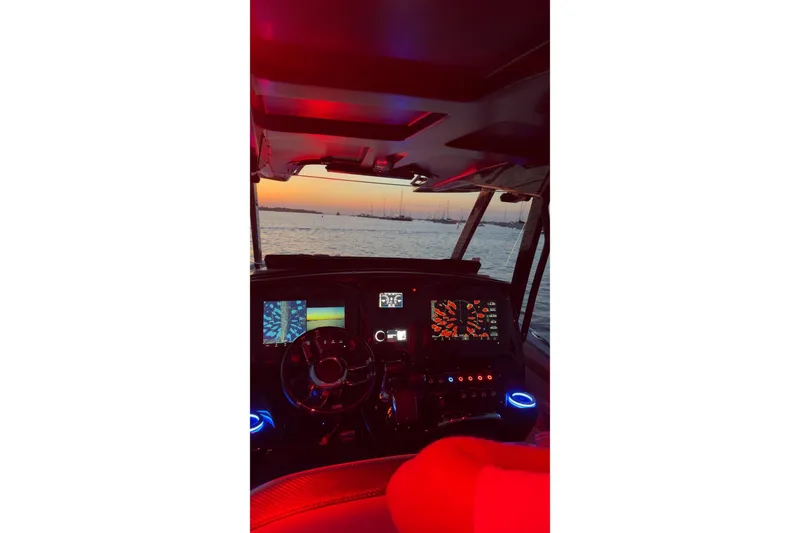 Slide: The Image of Cockpit view of 2023 Sunsation 32 CCX boat at sunset, featuring illuminated controls. - 6