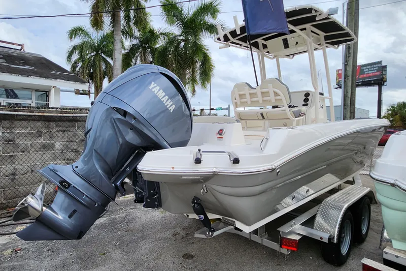Slide: The Image of 2023 Stingray 236 CC boat with Yamaha engine on trailer, parked outdoors. - 2