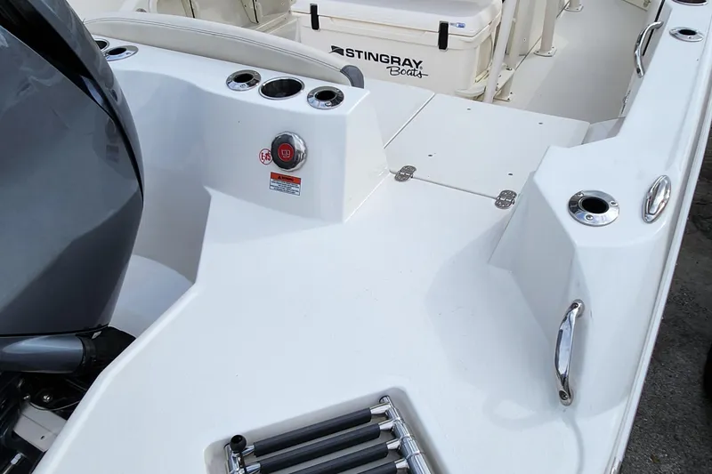 Slide: The Image of 2023 Stingray 236 CC boat deck with motor and cup holders. - 4