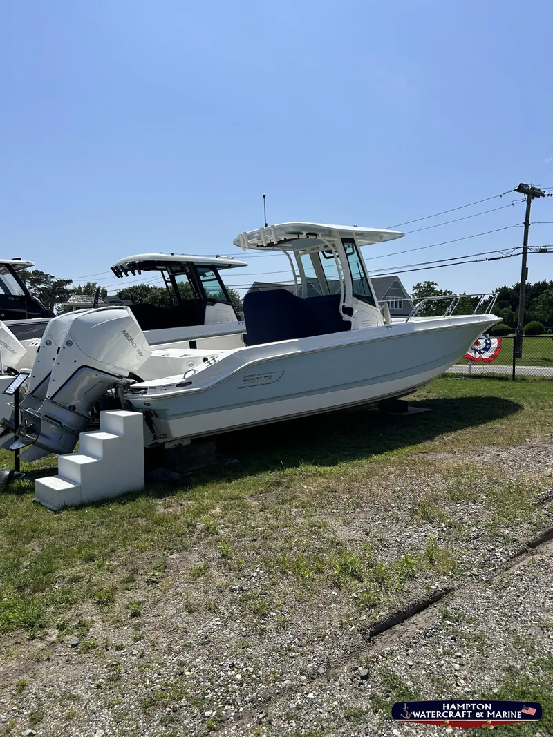 Slide: The Image of 2023 Boston Whaler 280 Dauntless boat displayed outdoors on grass. - 1