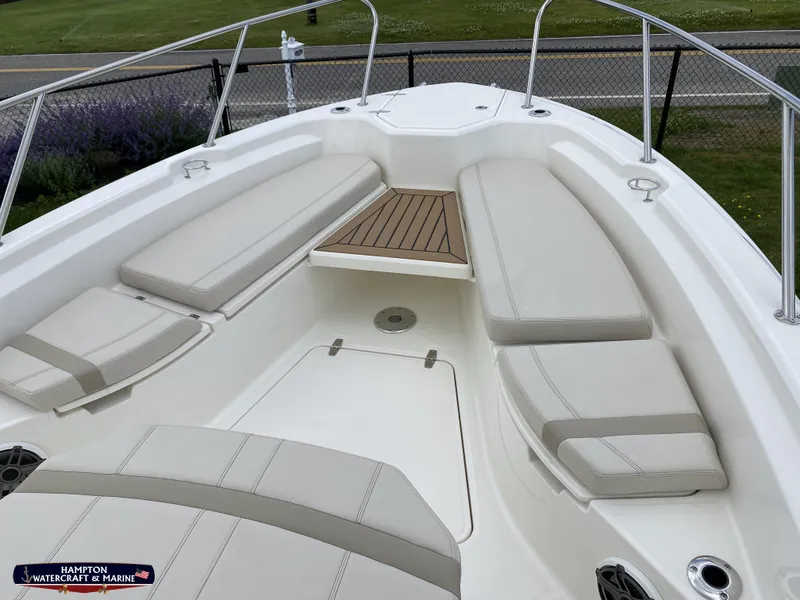 Slide: The Image of 2023 Boston Whaler 280 Dauntless boat interior with cushioned seating and wooden deck. - 22