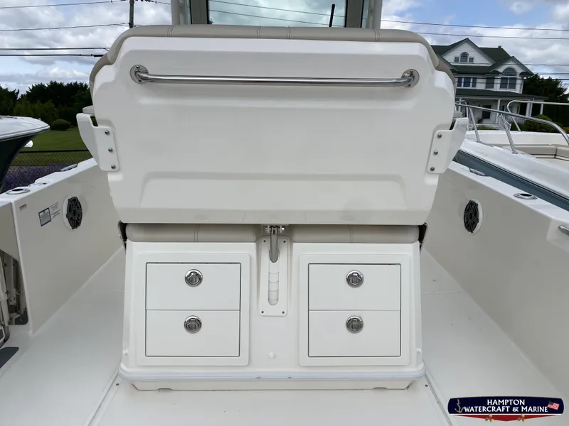 Slide: The Image of 2023 Boston Whaler 280 Dauntless boat with center console and T-top, docked near residential area. - 9