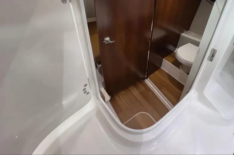 Slide: The Image of 2026 Chaparral 310 OSX boat interior bathroom with wooden flooring and modern fixtures. - 2
