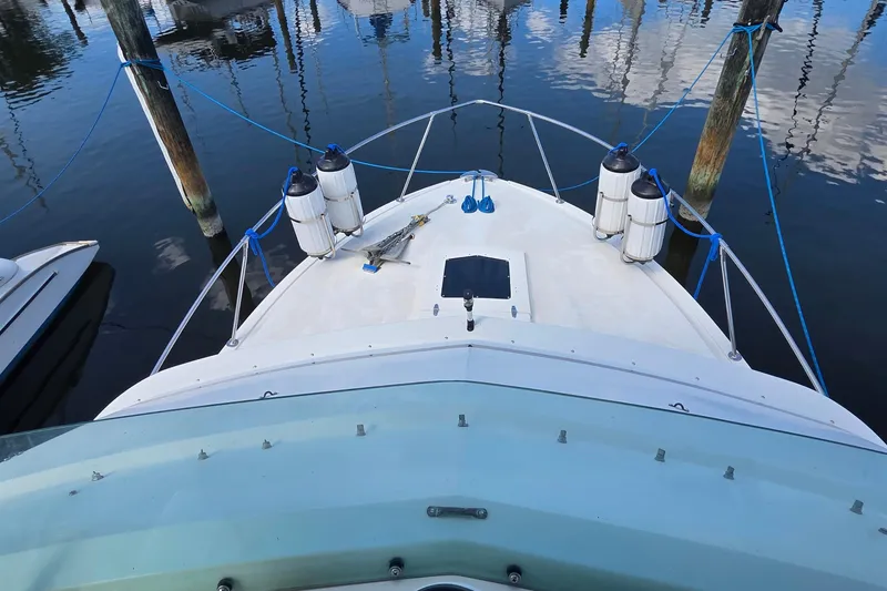 Slide: The Image of 1983 Bertram 28 Flybridge Cruiser docked, view from flybridge, with fenders and anchor visible. - 12