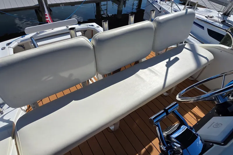 Slide: The Image of 1983 Bertram 28 Flybridge Cruiser with white seating and wooden deck. - 13