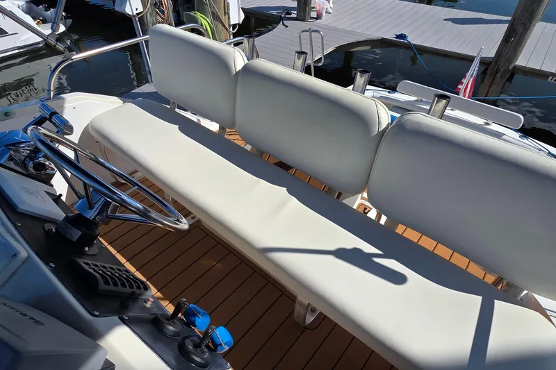 Slide: The Image of 1983 Bertram 28 Flybridge Cruiser interior with white seating and steering wheel. - 14