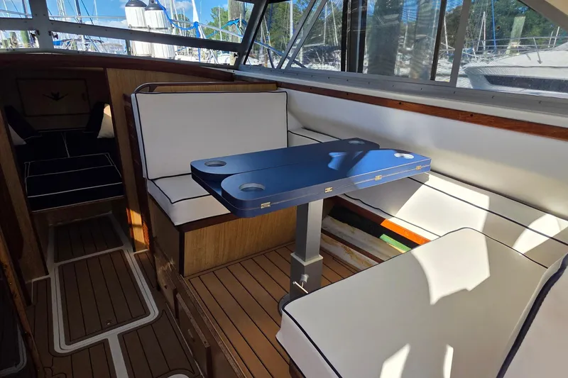 Slide: The Image of 1983 Bertram 28 Flybridge Cruiser interior with seating and table, featuring nautical design elements. - 16