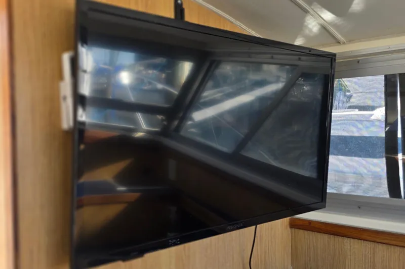 Slide: The Image of Flat-screen TV mounted inside 1983 Bertram 28 Flybridge Cruiser boat interior. - 19