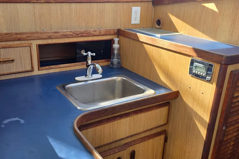 Slide: The Image of 1983 Bertram 28 Flybridge Cruiser interior with sink and wooden cabinetry. - 20