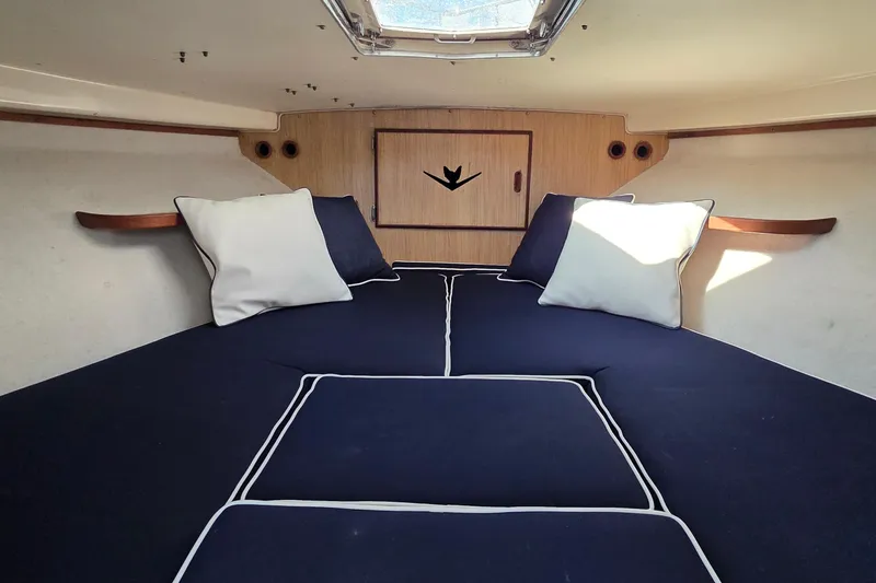 Slide: The Image of Cozy cabin interior of 1983 Bertram 28 Flybridge Cruiser with navy cushions and pillows. - 26