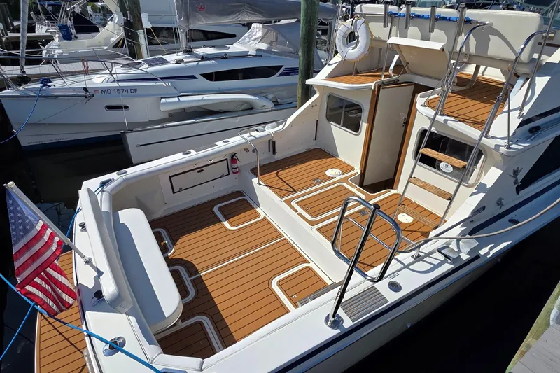 Slide: The Image of 1983 Bertram 28 Flybridge Cruiser with wooden deck, docked at marina. - 4