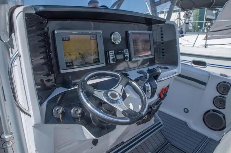 Slide: The Image of 2014 Nor-Tech 390 Sport Cuddy Center Console dashboard with navigation screens and steering wheel. - 12