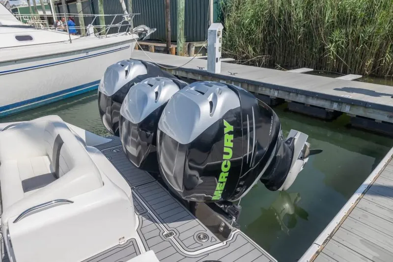 Slide: The Image of 2014 Nor-Tech 390 Sport Cuddy Center Console with triple Mercury outboard engines at dock. - 14