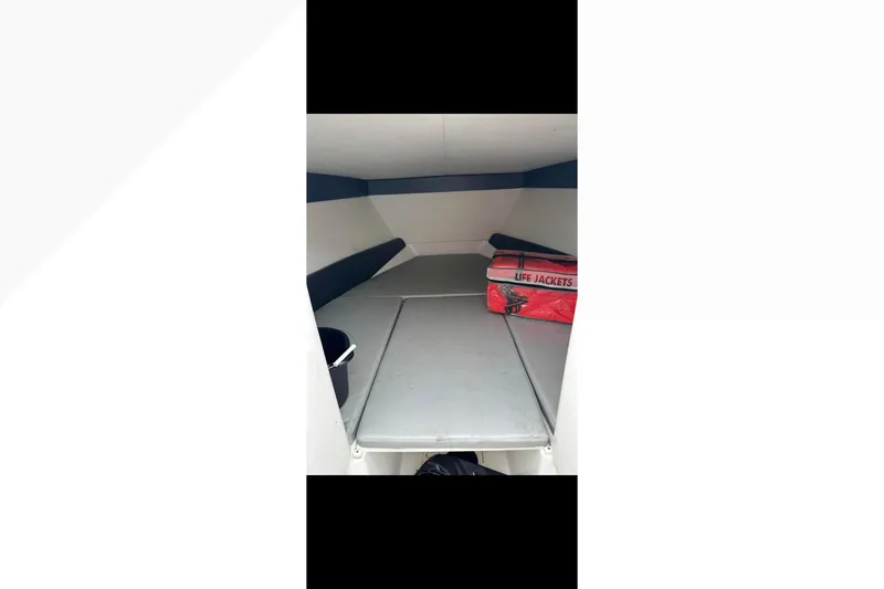 Slide: The Image of 2014 Nor-Tech 390 Sport Cuddy Center Console interior with life jackets and seating area. - 3