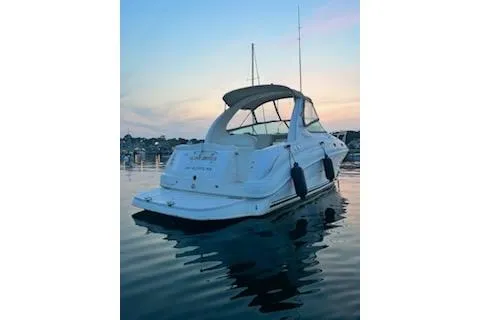Slide: The Image of 2003 Sea Ray 280 Sundancer boat on calm water at sunset. - 2