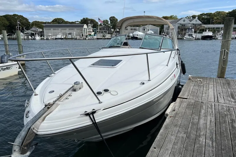 Slide: The Image of 2003 Sea Ray 280 Sundancer docked at a marina, surrounded by water and boats. - 3
