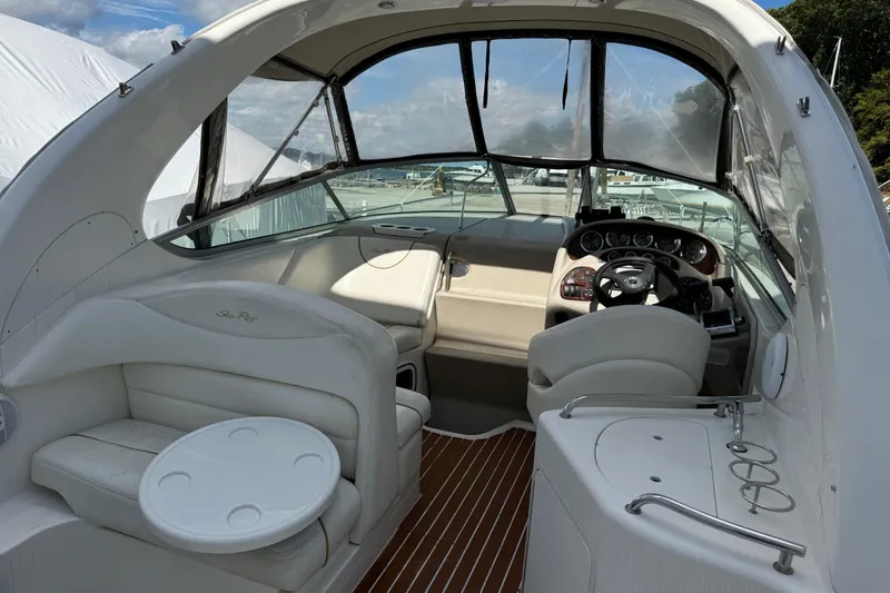 Slide: The Image of 2003 Sea Ray 280 Sundancer boat interior with helm, seating, and wooden flooring. - 5
