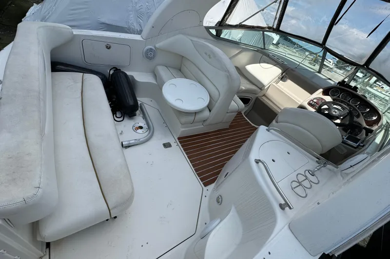 Slide: The Image of 2003 Sea Ray 280 Sundancer interior with white seating and helm, showcasing luxury design. - 6