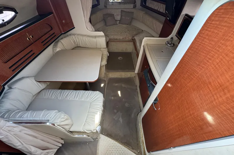 Slide: The Image of Interior of 2003 Sea Ray 280 Sundancer with dining area, kitchenette, and sleeping space. - 7