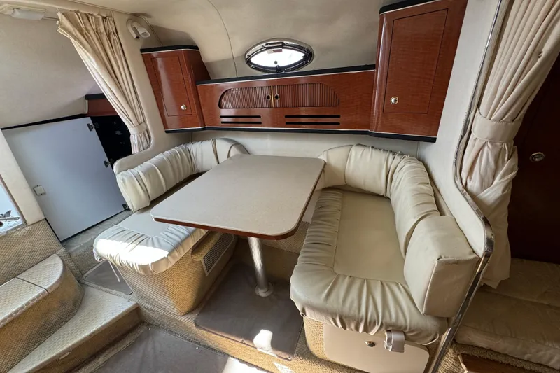 Slide: The Image of Interior of 2003 Sea Ray 280 Sundancer with cozy seating and wooden cabinetry. - 8