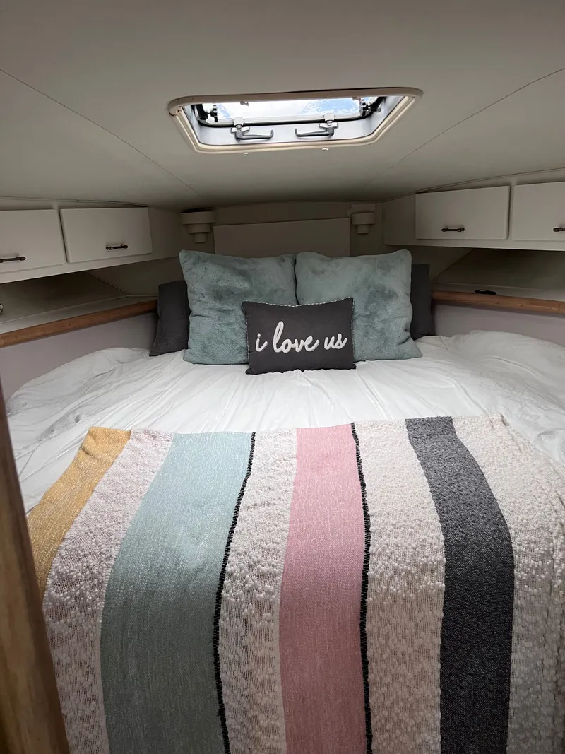 Slide: The Image of Cozy cabin interior of 1992 Wellcraft 43 Portofino with colorful bedding and decorative pillows. - 11