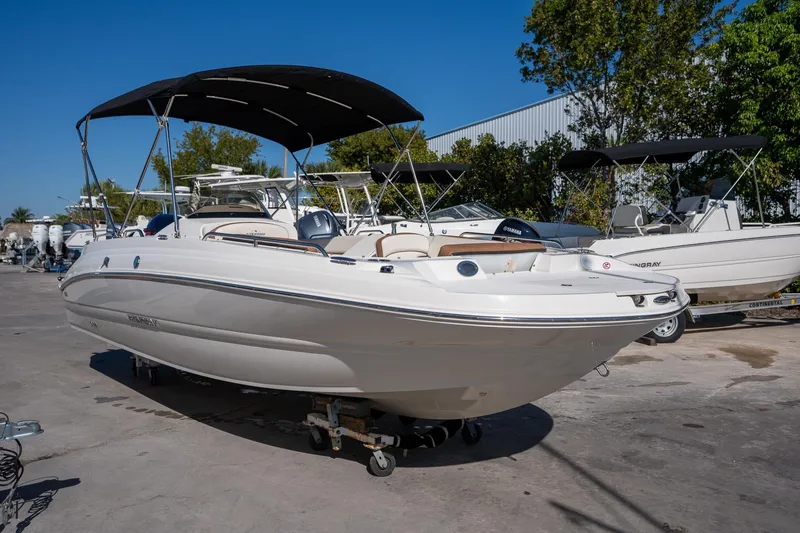 The Image of 2024 Stingray 192 SC boat with canopy, parked outdoors on a sunny day. - 0
